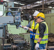 © Jack Tamrong - Engineer and coworker wearing safety uniform, hard helmet and vest working with hard machinary in industrial factory