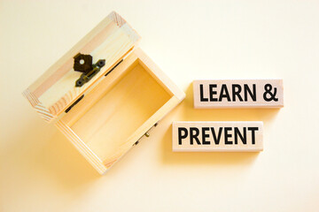 Poster - Learn and prevent symbol. Concept words Learn and prevent on wooden blocks on beautiful white table white background. Empthy wooden chest. Business learning and learn and prevent concept, copy space.