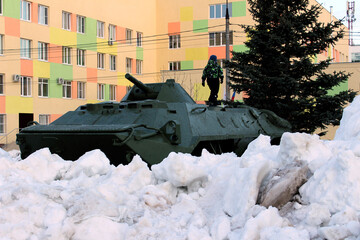 a little boy plays on military equipment a tank an armored personnel carrier