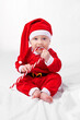 © Tabitha R/peopleimages.com - The biggest gift of all. Studio shot of a little boy dressed up in a santa costume.