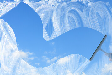 Washing of window with detergent and squeegee against blue sky