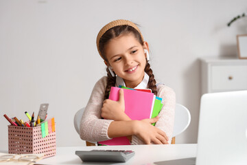 Sticker - Little girl in earphones with copybooks studying online at home