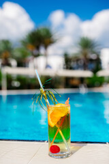 Two Colorful Tropical Cocktails near the Swimming Pool on the Background of Warm Blue Sea. Exotic Summer Vacation.