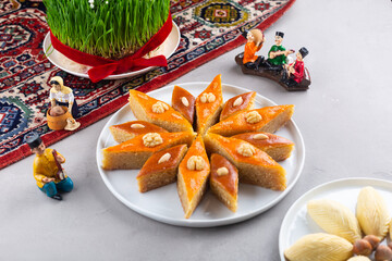 Wall Mural - Plate of Azerbaijani national pastries for Novruz pakhlava and shakarbura on ethnic rug or carpet for Novruz, spring equinox and new year celebration in March. Copy space  