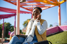 Cheerful Black Woman Talking On Smartphone In City