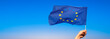 Europe flag with female hand. Banner with blue sky