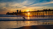 Surfer at Oceanside Pier. A colorful sunset image with reflections and pelicans passing.