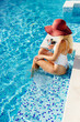 © shevtsovy - happy woman relax in swimming pool on summer vacations. Sexy woman in swimsuit splashing water drops and having fun. Summer vacation time.