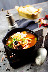 Canvas Print - Pan Asian traditional seafood soup with mussels, calamari, mushrooms served with fresh parsley herbs