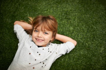 Canvas Print - Shes a charmer. Little girl lying on the grass with her hands behind her head.