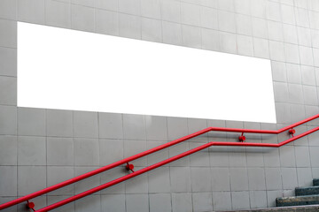 Long white empty commercial advertising poster located on concrete wall over red handrail near underground entrance