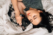 © andrey - top view. happy pretty brunette woman with a French Bulldog puppy in a bed.