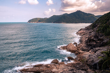 Wall Mural - wild place, stone shore, top view, turquoise sea waves at sunset