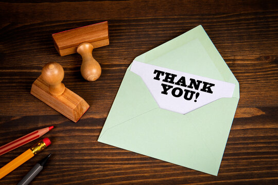 Thank You. Written text Inside An Envelope Letter. Wood texture background
