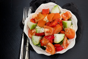 Poster - Fresh uncooked vegetables courgette, pepper and tomato in white bowl preparation food on dark