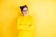 © Irene - Young beautiful woman wearing casual sweater over isolated yellow background thinking looking tired and bored with crossed arms