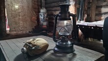 A Wooden Dugout In Which A Kerosene Lamp Burns. Light From The Window Penetrates Into The Room.