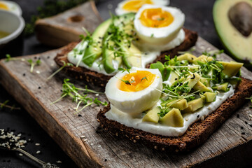 Wall Mural - Two toasts with avocado, poached egg and microgreen. diet or vegetarian food. Top view