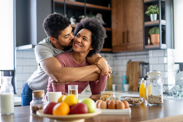 Wall Mural - Happy couple having breakfast together in the kitchen