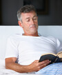 © D Laflor/peopleimages.com - Hes reading a best-seller. Shot of a mature man reading a book in bed.