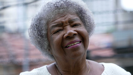 Wall Mural - Portrait of a senior African woman with gray hair standing in urban street smiling at camera