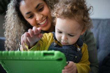 Mother and Toddler playing on a Digital tablet together
