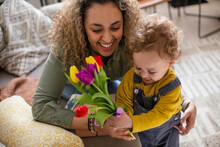 Toddler Giving Mother Flowers For Mothers Day