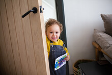 Toddler Opening Door Carrying A Homemade Card