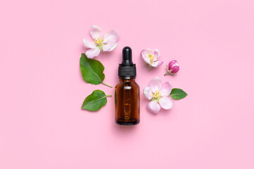 Wall Mural - Clean brown glass cosmetic bottles with dropper, delicate spring flowers on pink background flat lay top view. Spring concept of natural organic cosmetics, beauty herbal product spa aroma oil. Mockup