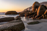 Fototapeta Boho - Clifton 4th beach at sunset.  Beautiful tranquil beach in Cape Town, South Africa dotted with huge granitic boulders and super white sand.  