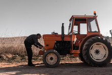 Old Tractor Driver Taking Instrument From Toolkit For Repair
