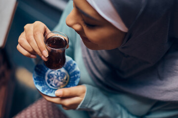 Wall Mural - Close-up of Muslim woman drinks Turkish tea.