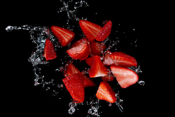 Fototapete - Freeze motion of sliced strawberries in water splash.