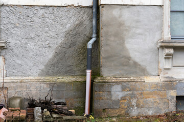 Water damage of a house. Wet exterior wall caused by a leakage in a tube of the roof gutter. Rain water is absorbed by the building. A time and cost expensive repair is necessary.