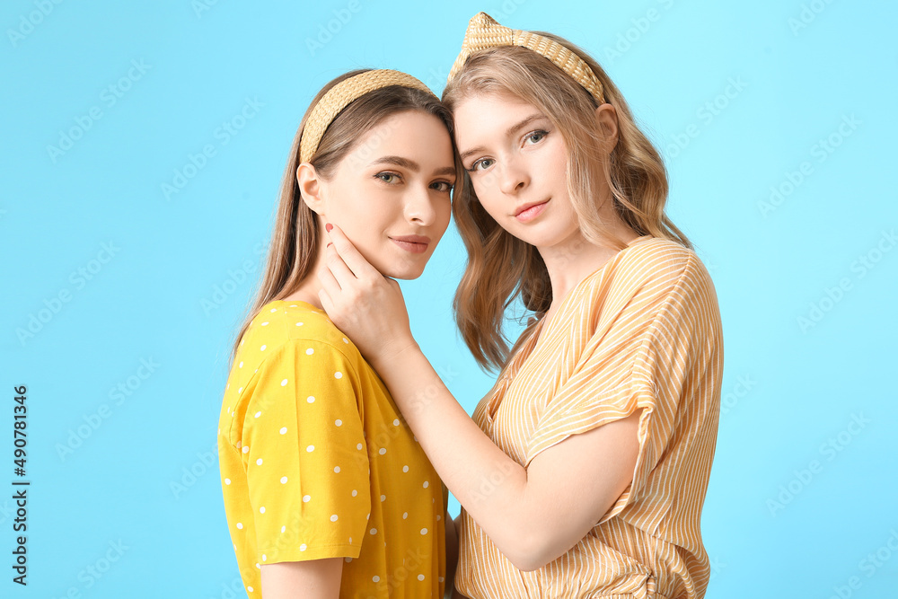 Portrait of young sisters on color background