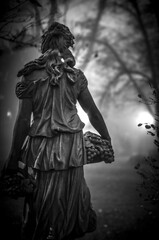 Canvas Print - Vertical grayscale shot of a lone sculpture captured from the back