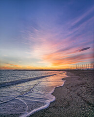 Poster - Vertical scenic shot of the sea during sunset under the sky and beautiful clouds