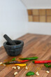 Vertical shot of colorful peppers, mortar and pestle on a wooden table