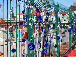 Sticker - Traditional and colorful evil eye decorations hanging on a fence