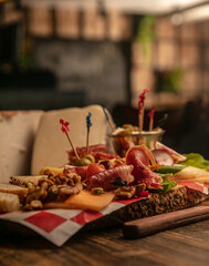 Wall Mural - Top view of a cheese set  (camembert, brie, Roquefort) and olives on a wooden board