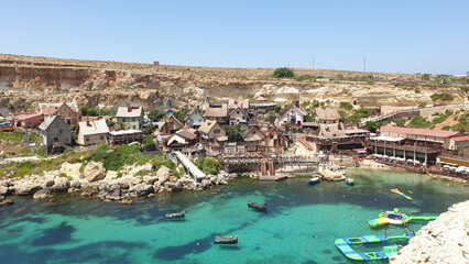 Canvas Print - View of the houses near the beach and the crystal clear water with multiple boats