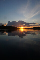 Wall Mural - A beautiful sunset on the horizon with a big lake and a cloud in the sky