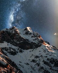 Wall Mural - Vertical shot of snowy mountains under a mesmerizing starry sky