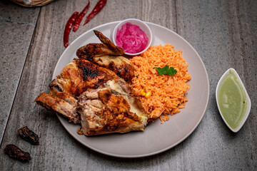 Wall Mural - Closeup shot of grilled chicken peaces with rice porridge and red cabbage with sauce pot