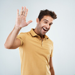 Aufkleber - Are we going to do a high five. Portrait of a cheerful young man smiling brightly with his one hand in the air while standing against a grey background.