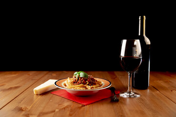 Poster - Plate with delicious pasta with the bottle and a glass of wine on the wooden table