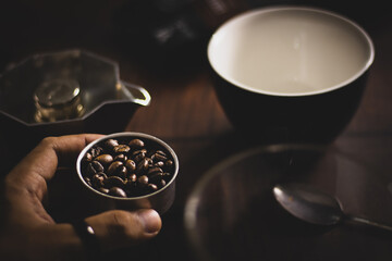 Sticker - Man's hand holding coffee beans next to a mug and a plate