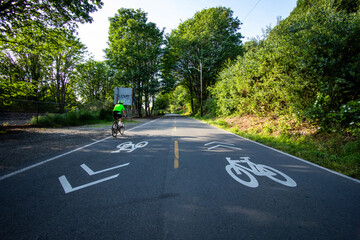 Sticker - Cyclist riding on the empty road with signs on a sunny day