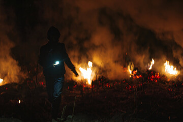 Poster - Silhouette shot of the people against fire in the field at night