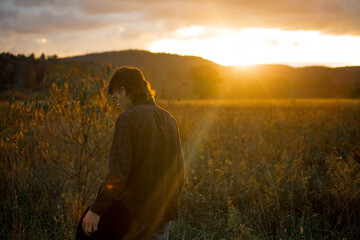 Wall Mural - photo of a man walking alone in nature at sunset